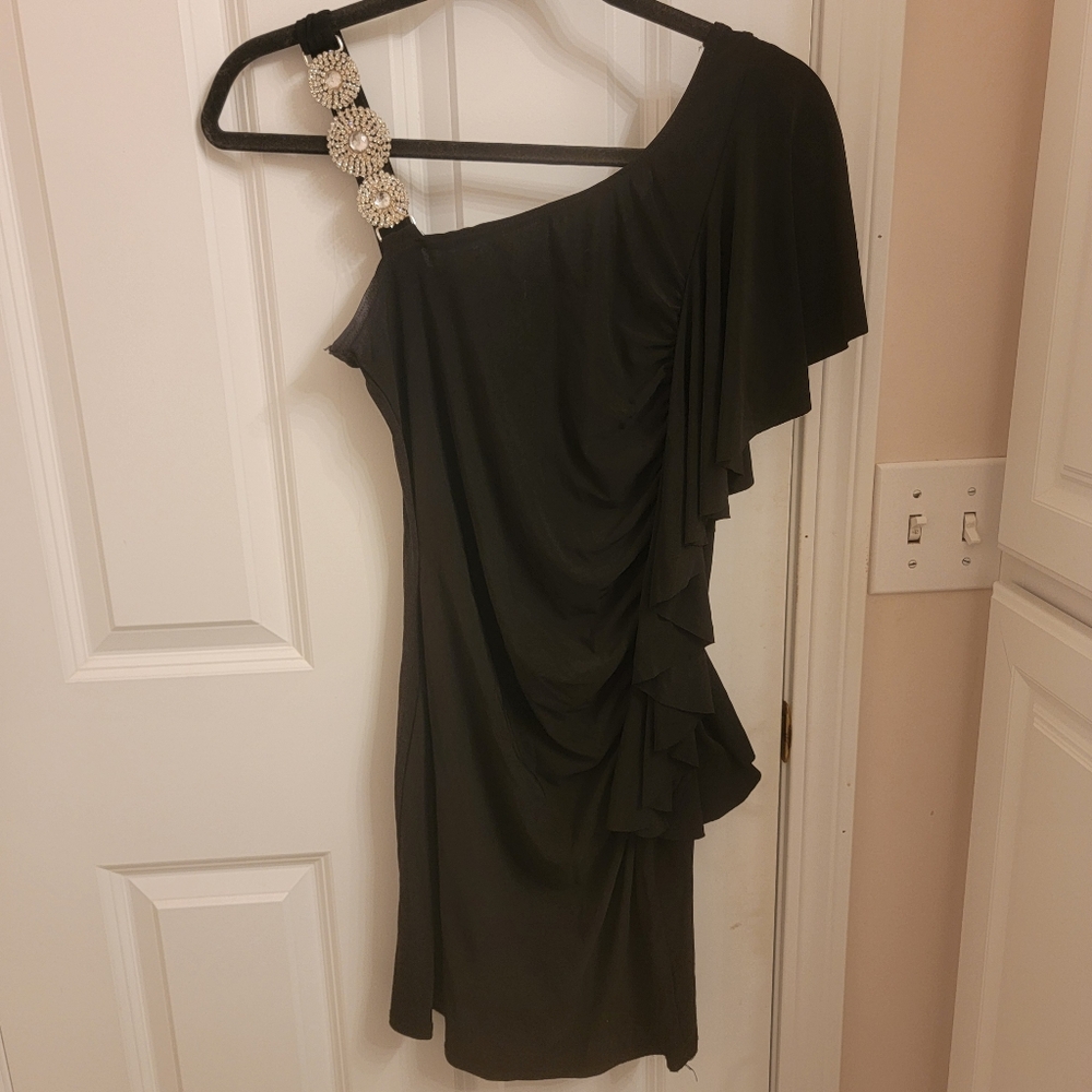 Black form fitting mini dress with ruffled one side and beaded shoulder.